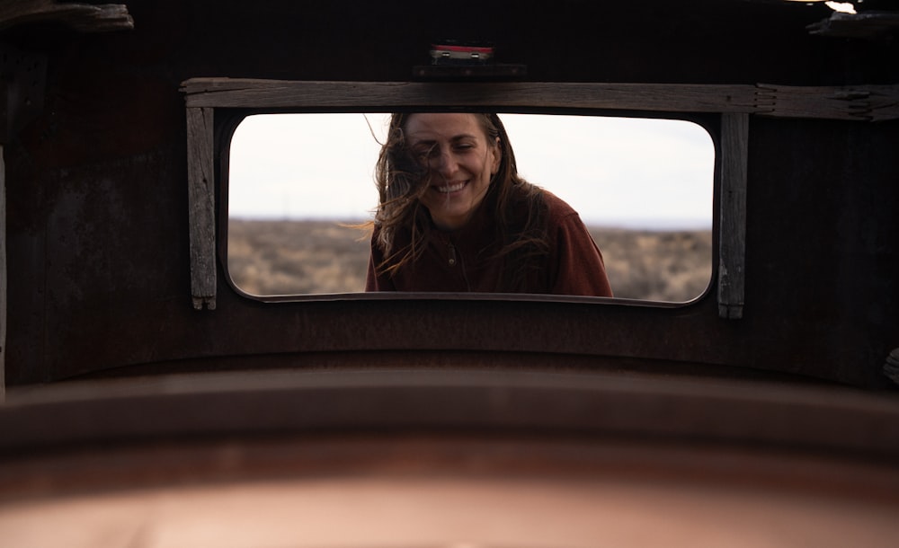 a woman is looking at herself in a mirror