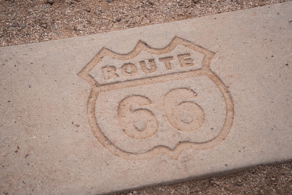 a route 66 sign carved into a sidewalk