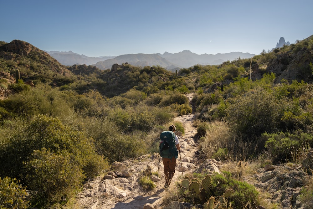 a person hiking up a trail in the mountains