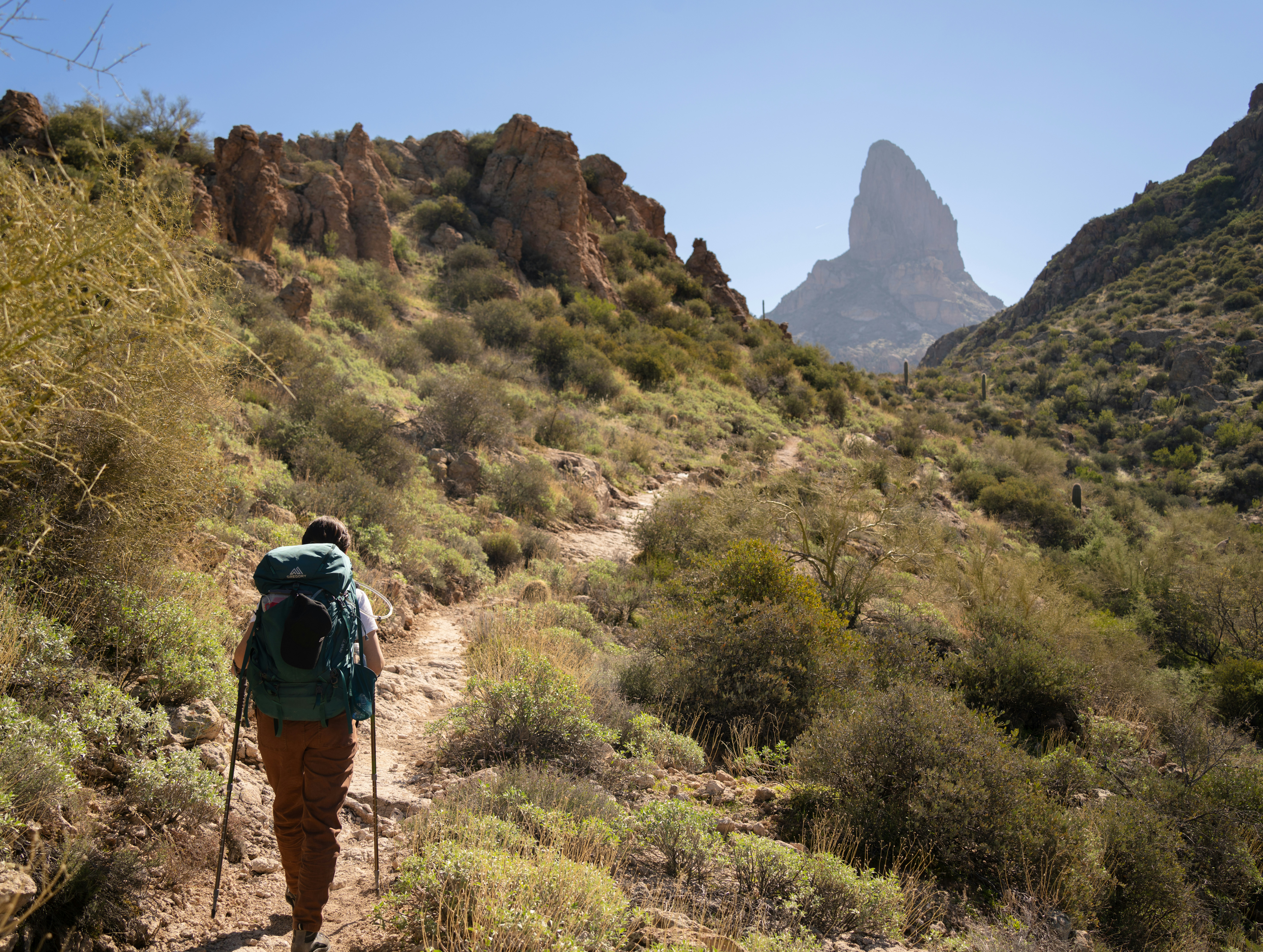 a man hiking up a trail in the mountains