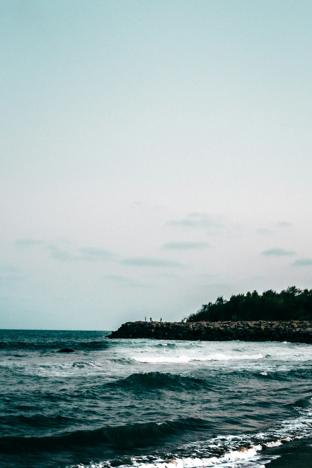 a person walking on a beach near the ocean