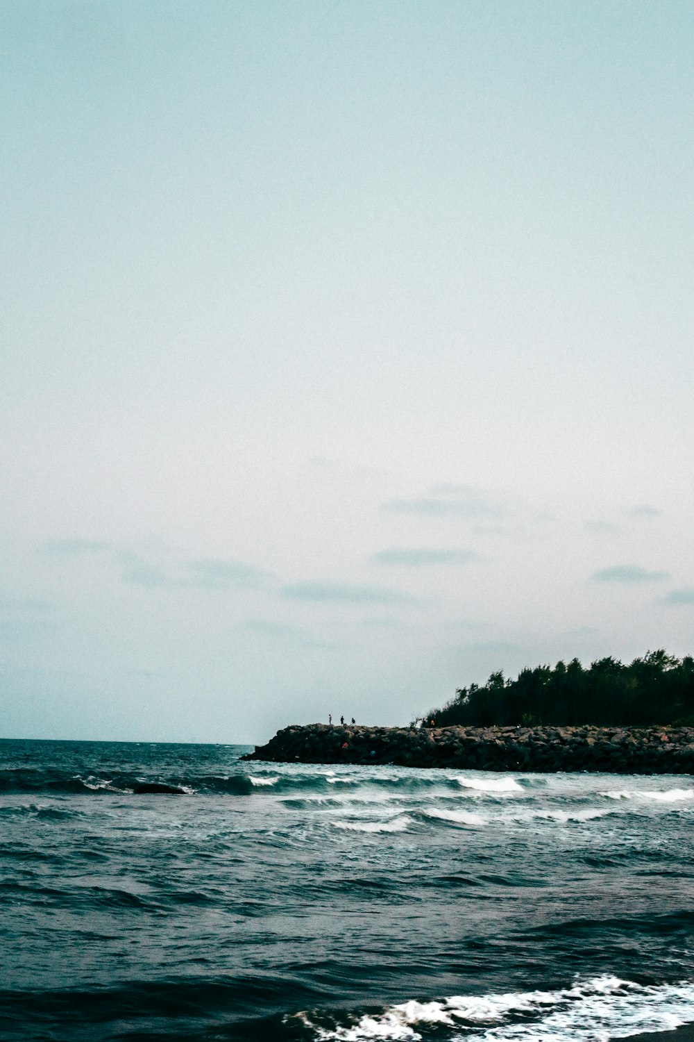 a lighthouse on a small island in the middle of the ocean