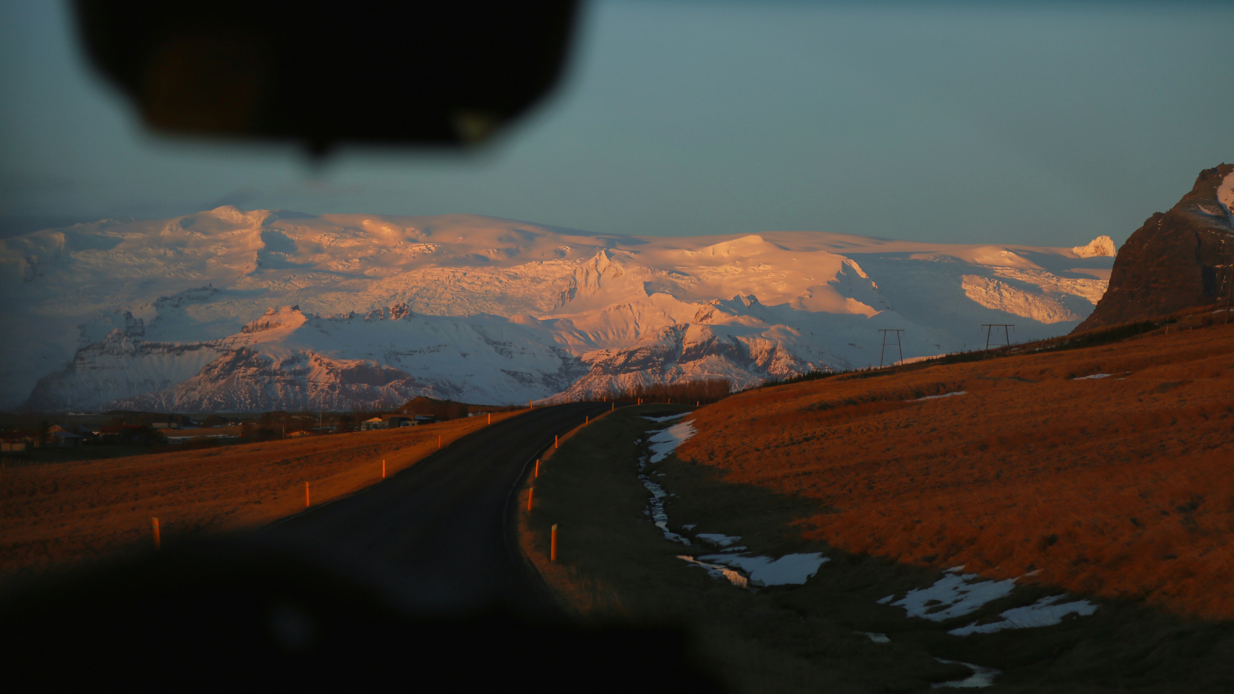 a view of a snowy mountain range from a vehicle