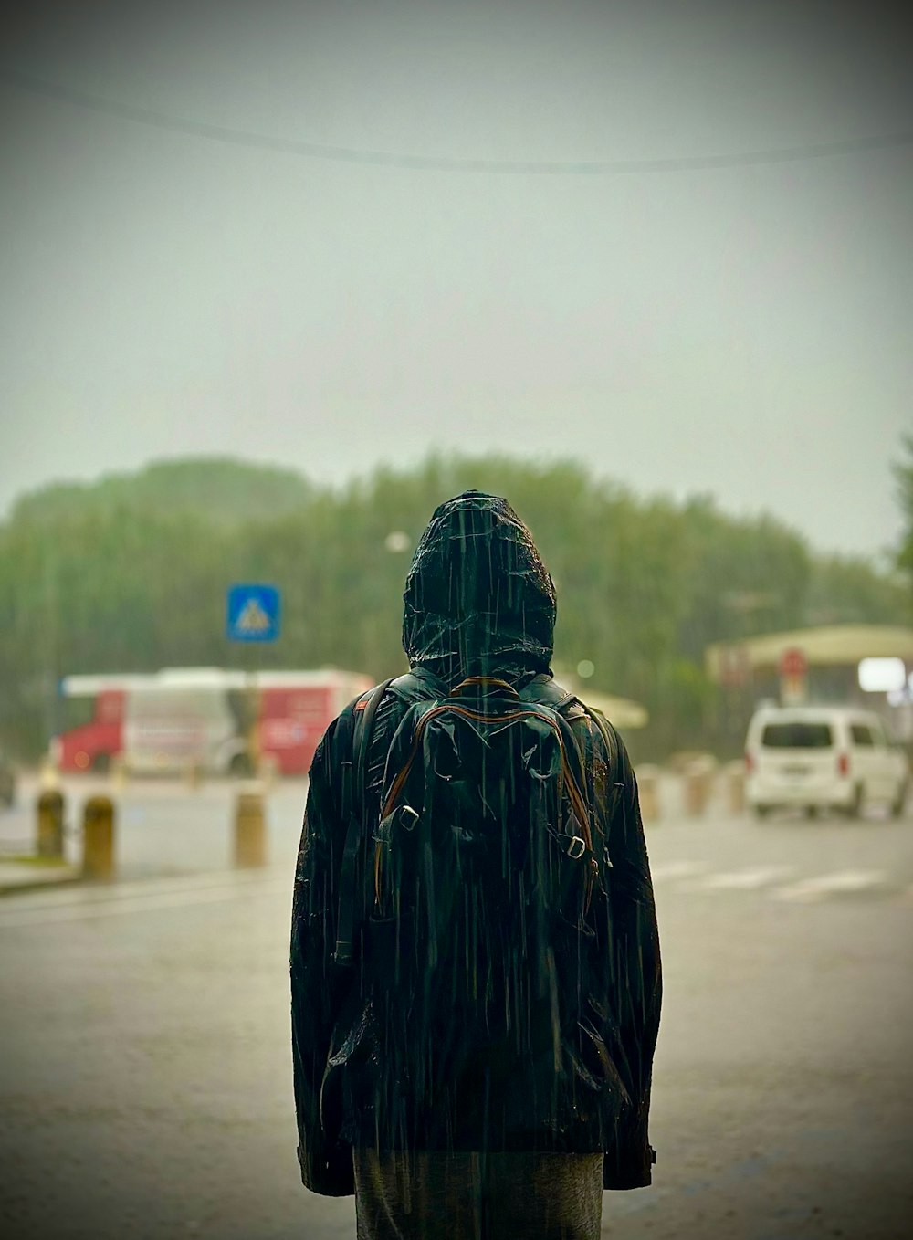a person standing in the middle of a street in the rain