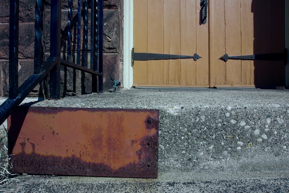 une boîte en métal rouillé posée devant une porte