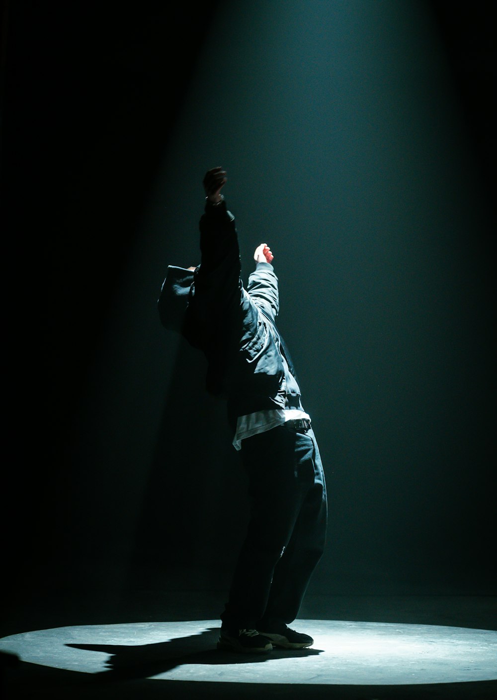 um homem em pé em um palco com os braços no ar