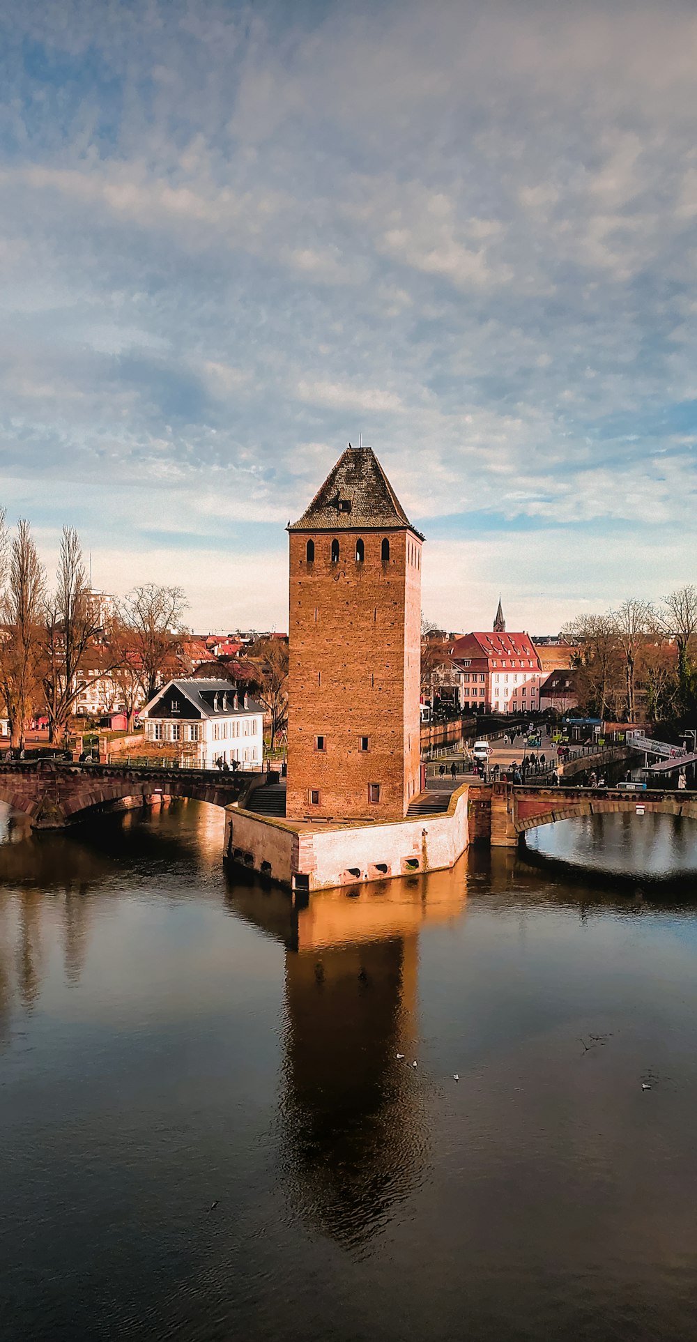 ein großer Backsteinturm, der auf einem Fluss sitzt