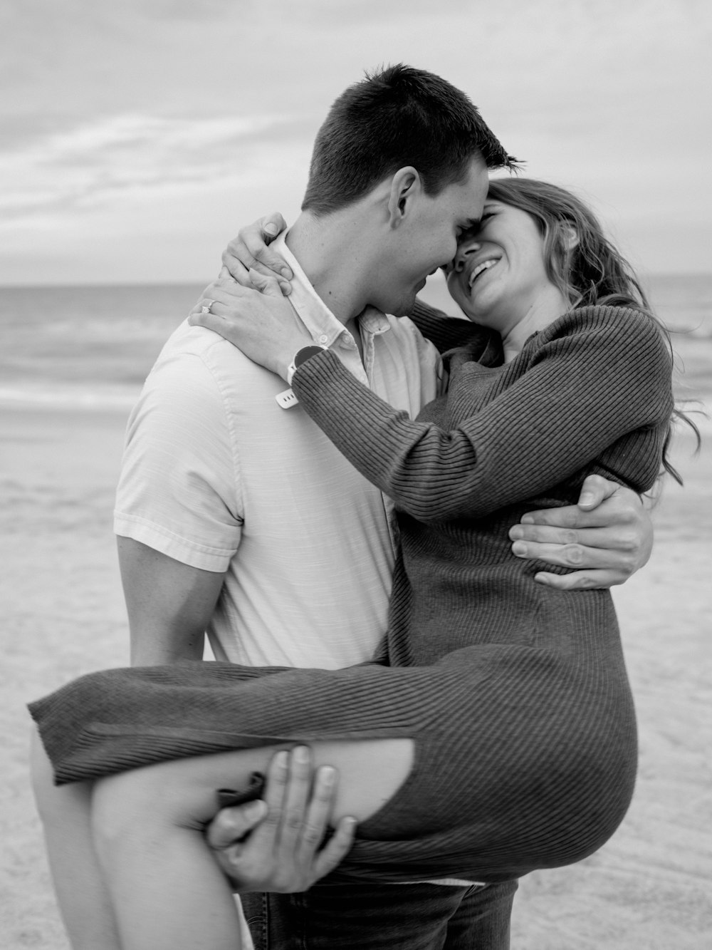 a man and woman hugging on the beach