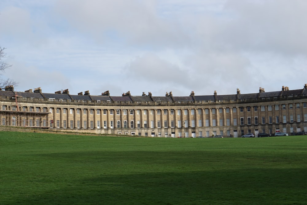 a large building sitting on top of a lush green field