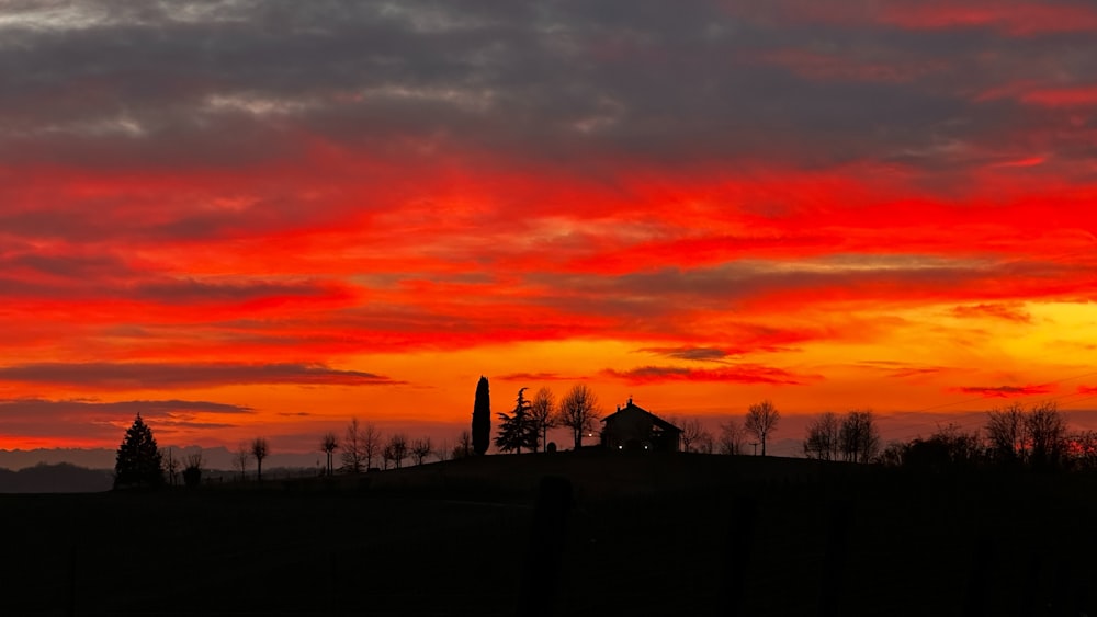 a red and orange sunset over a hill