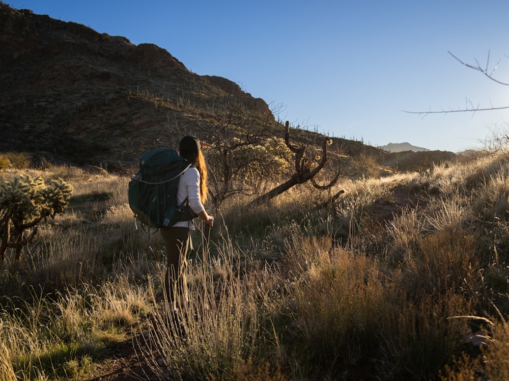 a person with a backpack walking through a field