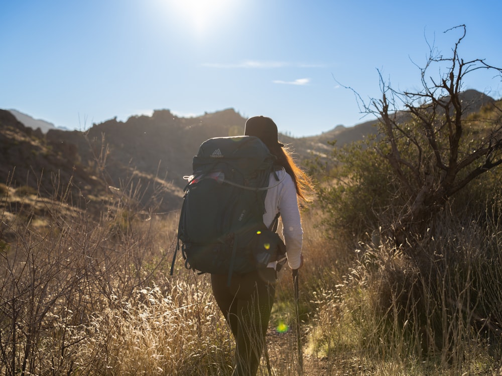 une personne avec un sac à dos marchant dans un champ