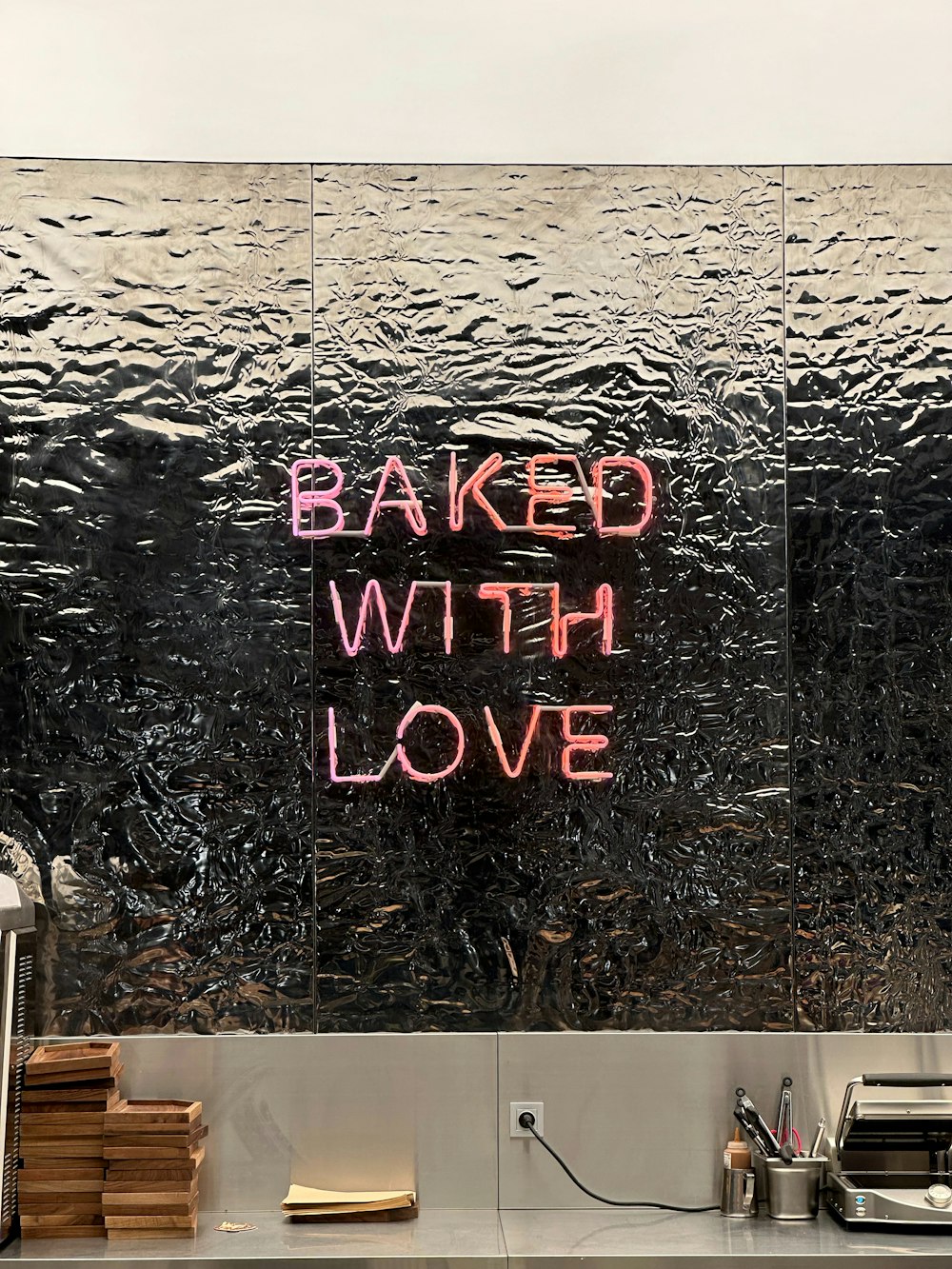 Ein Schild mit der Aufschrift "Mit Liebe gebacken" an einer Glaswand