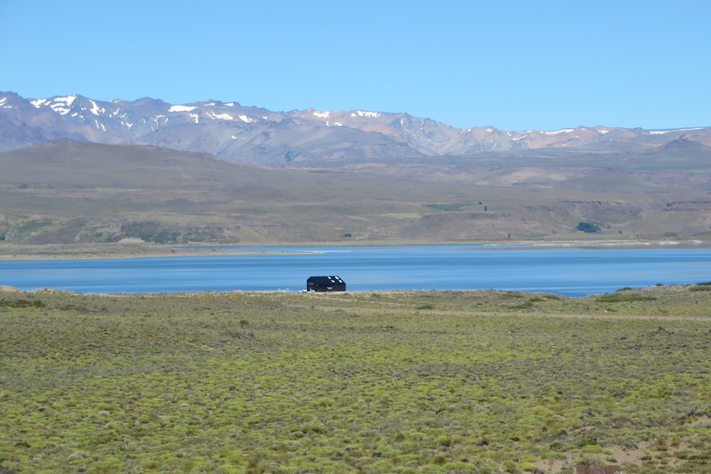 a car is parked on the side of a road near a lake