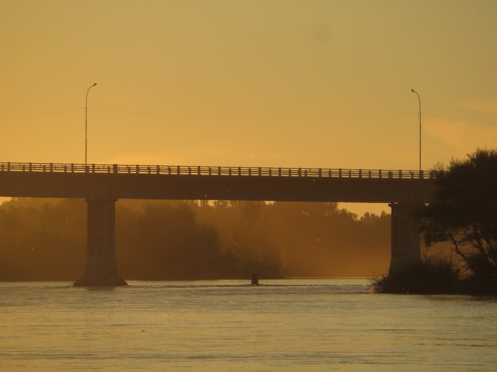 a bridge over a body of water at sunset