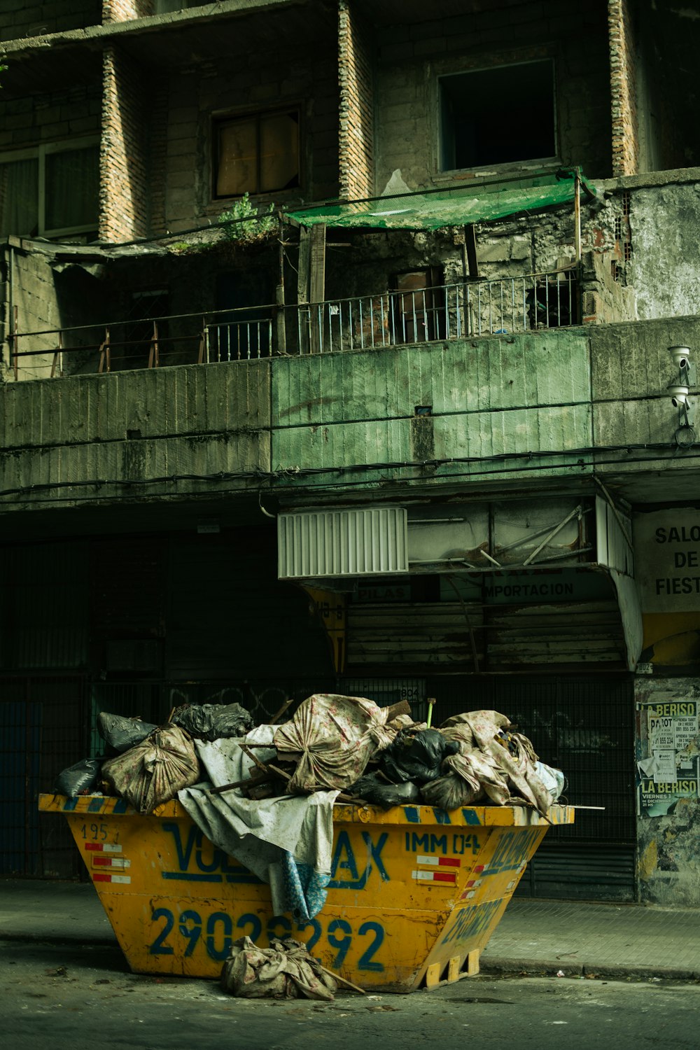 a dumpster filled with garbage sitting in front of a building