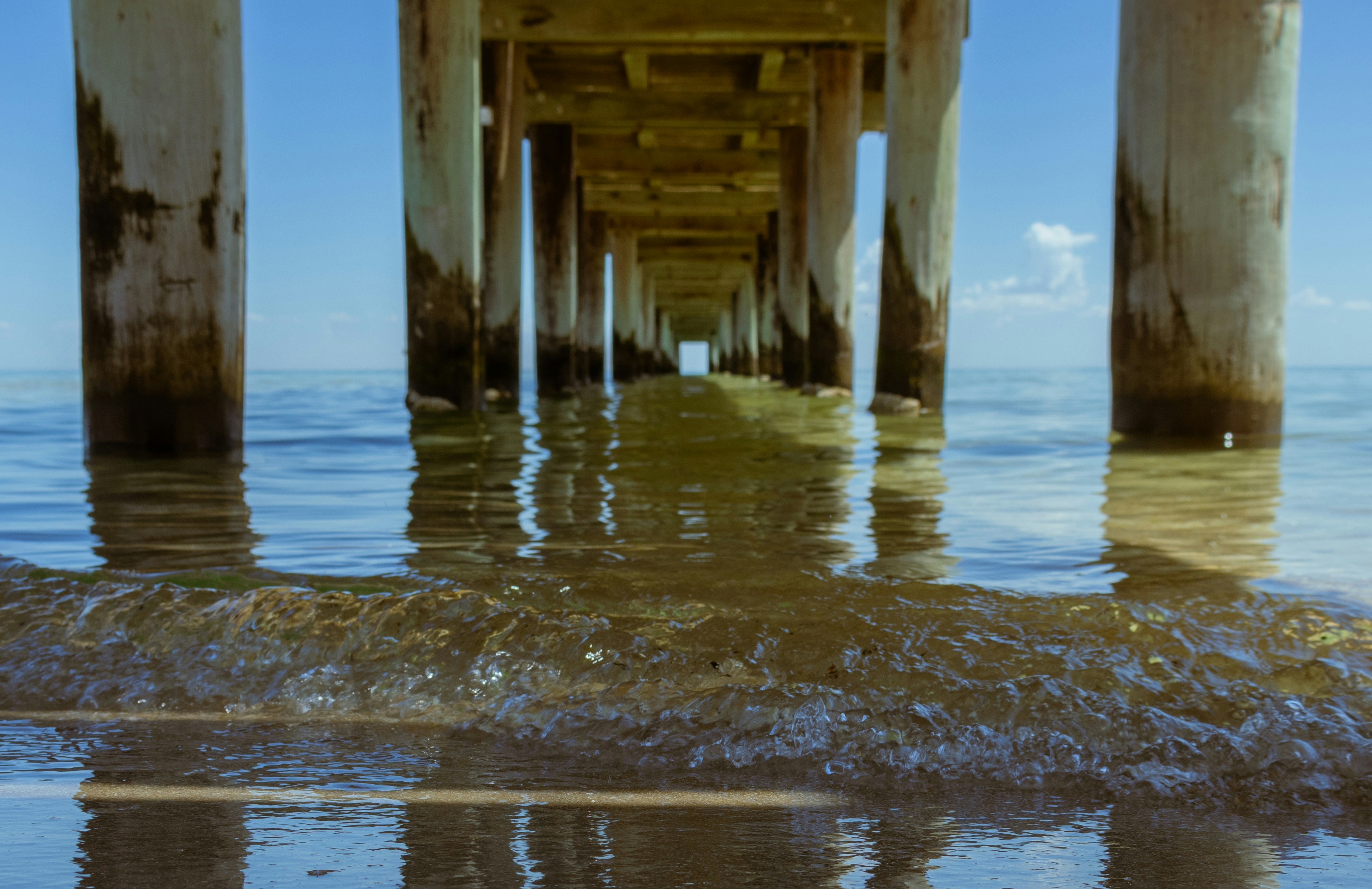 a view of the ocean under a pier
