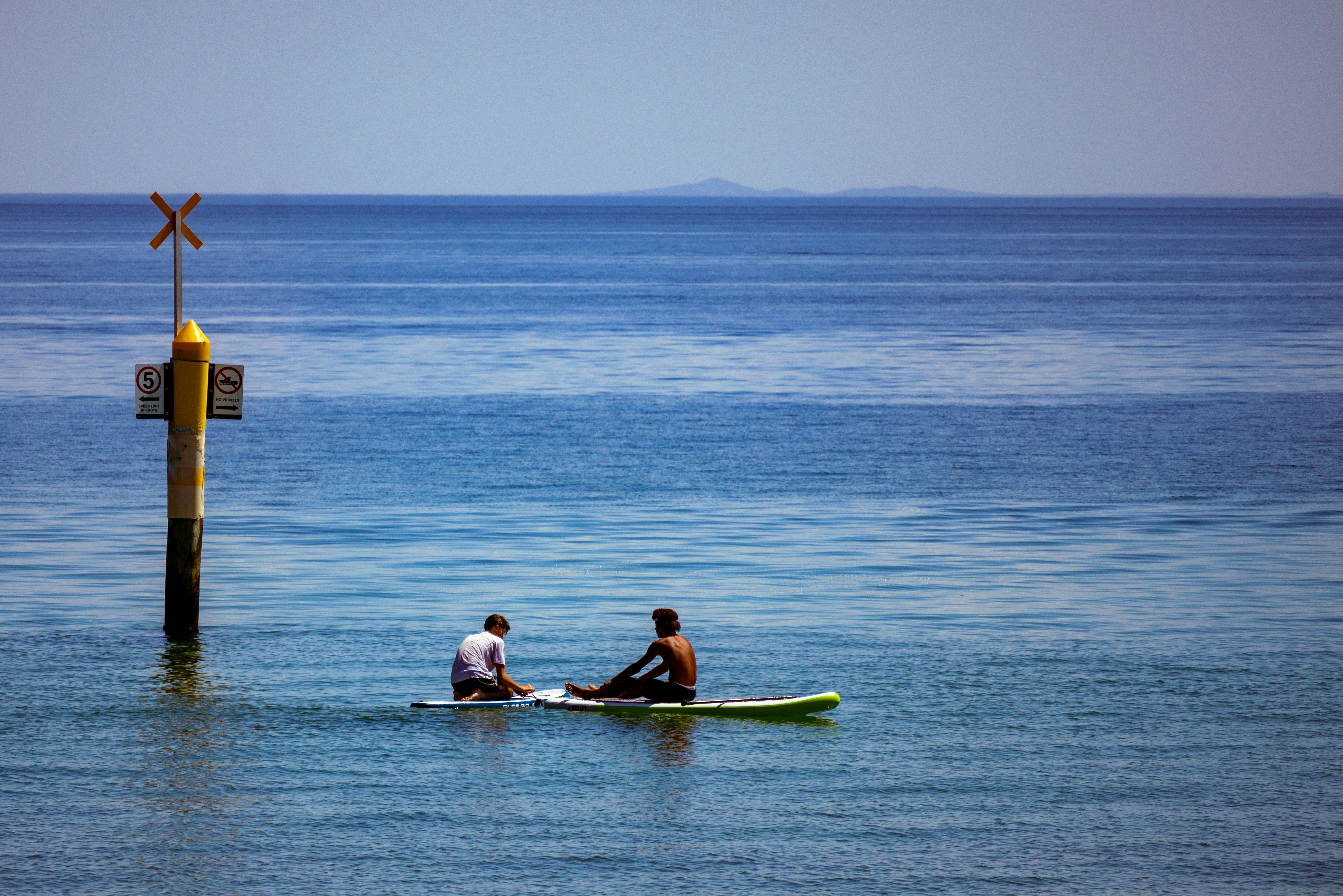 un couple de personnes assis sur une planche de surf dans l’océan