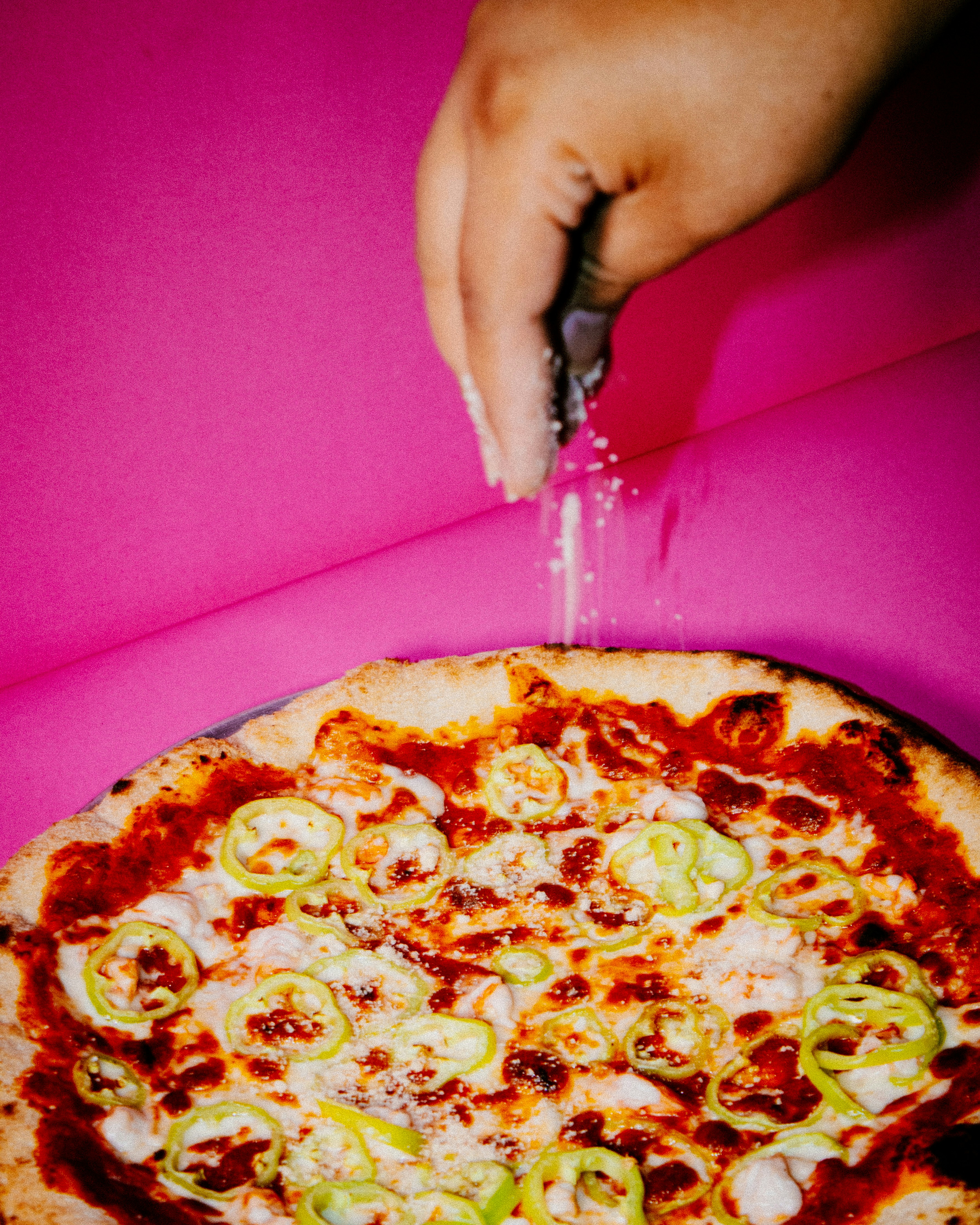 a person cutting a pizza with a knife