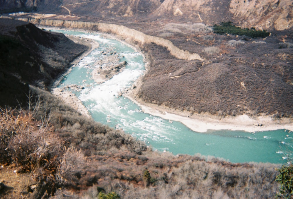 a river running through a valley surrounded by mountains