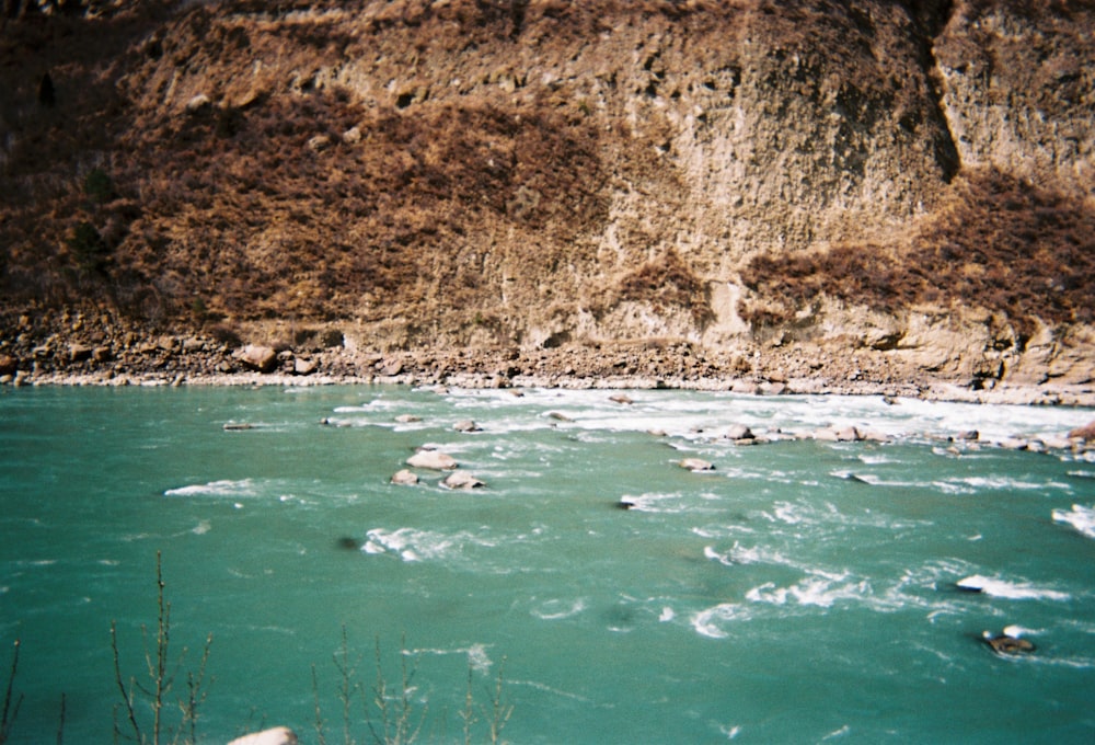 a body of water surrounded by a rocky cliff