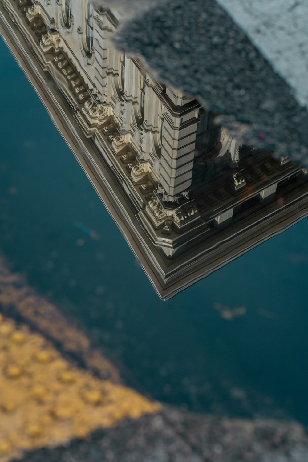 a reflection of a building in a puddle of water