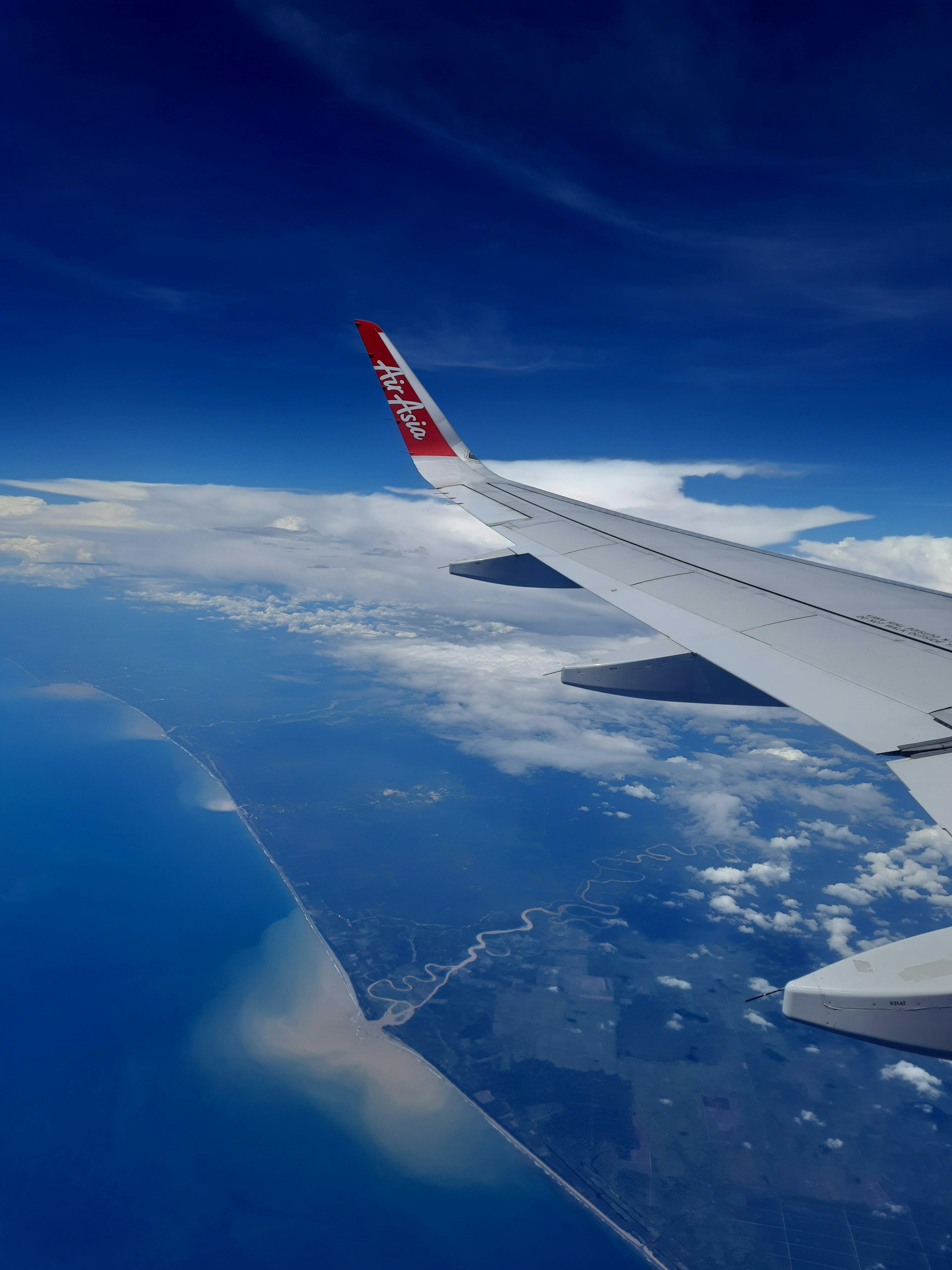 the wing of an airplane flying over the ocean
