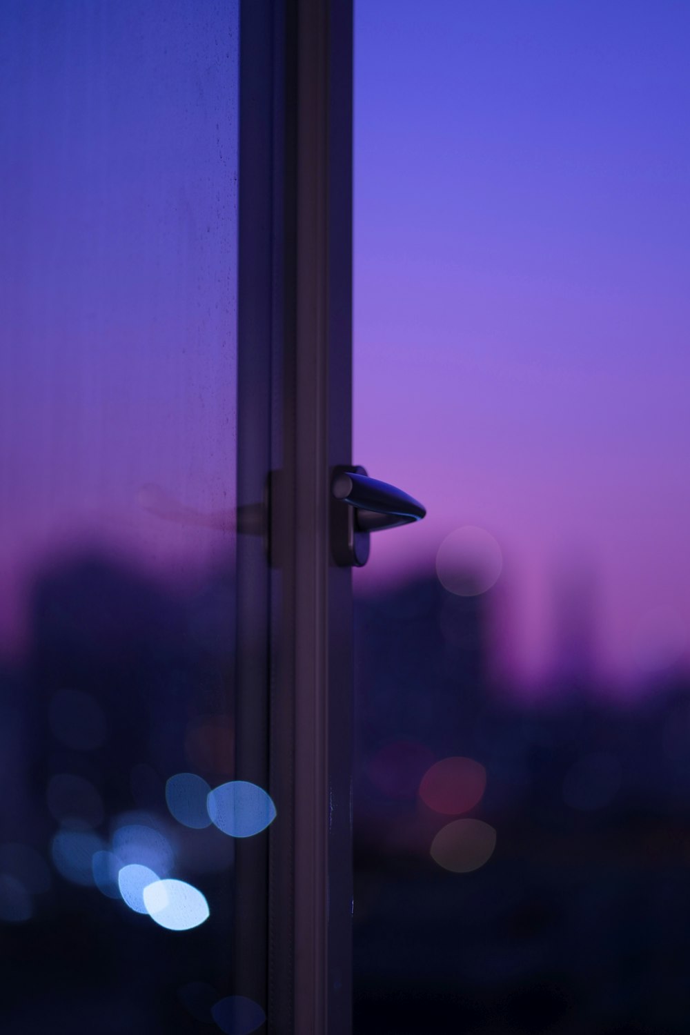 ein Fenster mit Blick auf eine Stadt bei Nacht