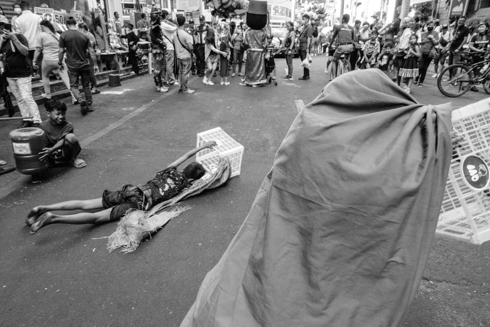 a black and white photo of a person laying on the street