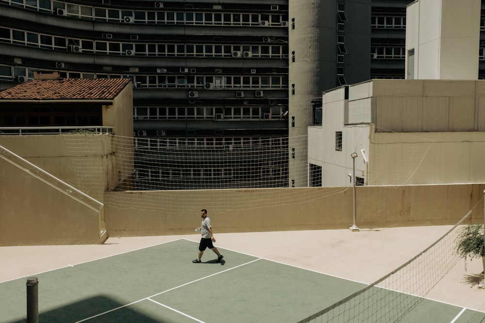 a man standing on top of a tennis court holding a racquet