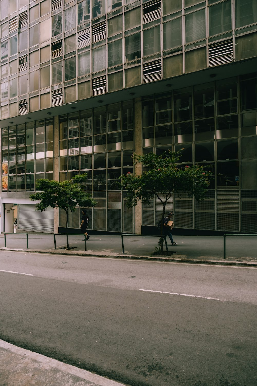 a man sitting on a bench in front of a tall building