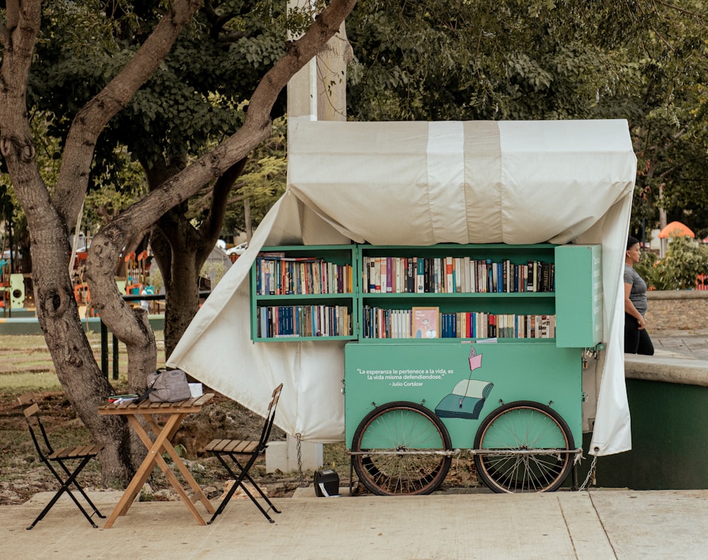 a green and white cart with a book shelf on top of it