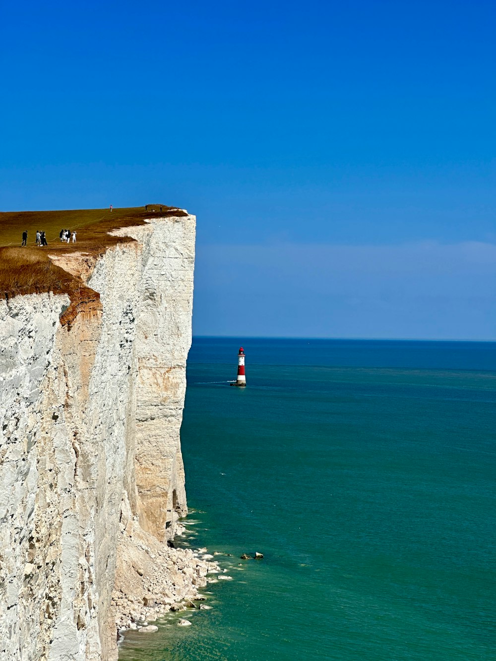 a lighthouse on a cliff overlooking the ocean