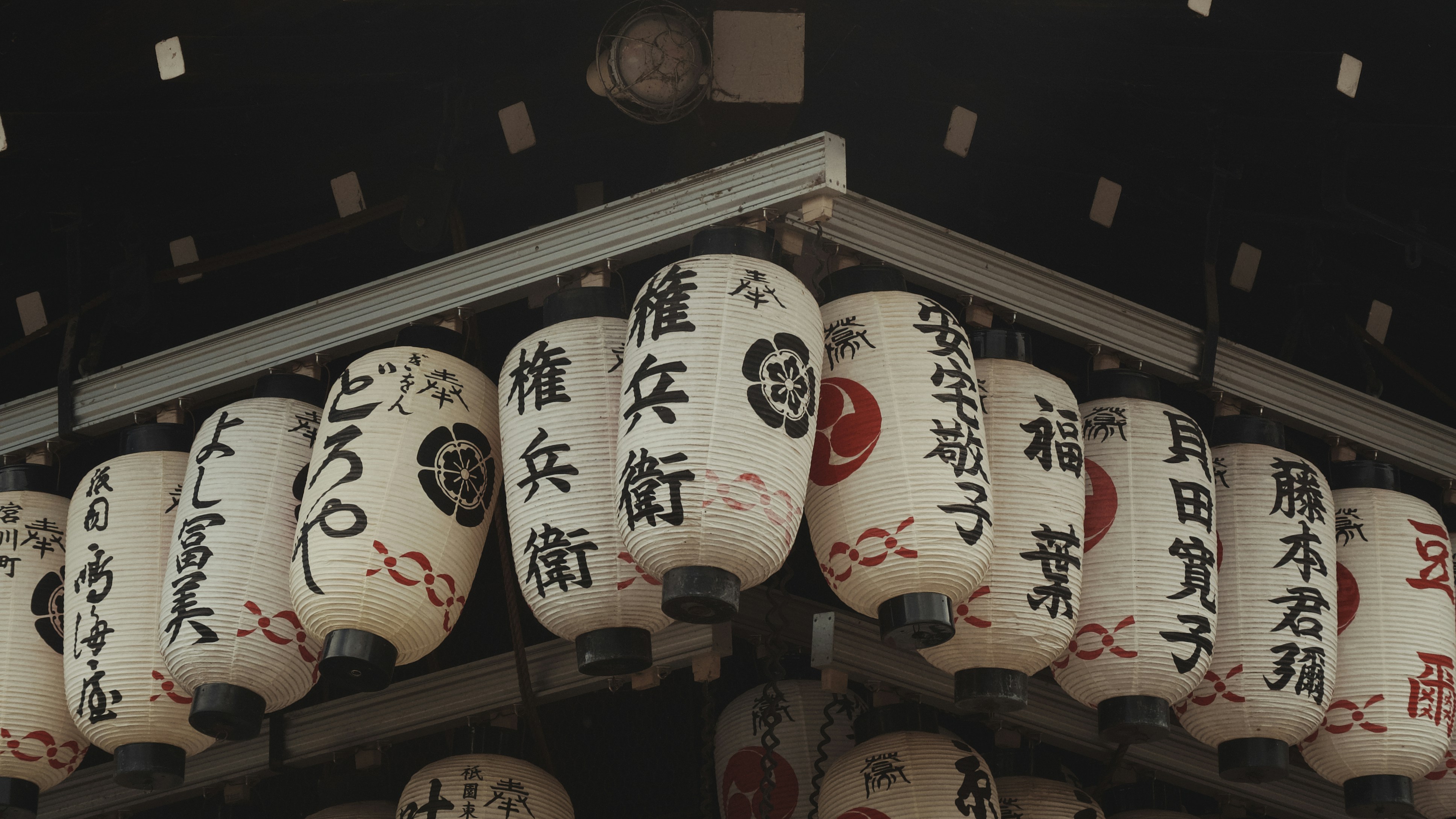 a group of oriental lanterns hanging from a roof