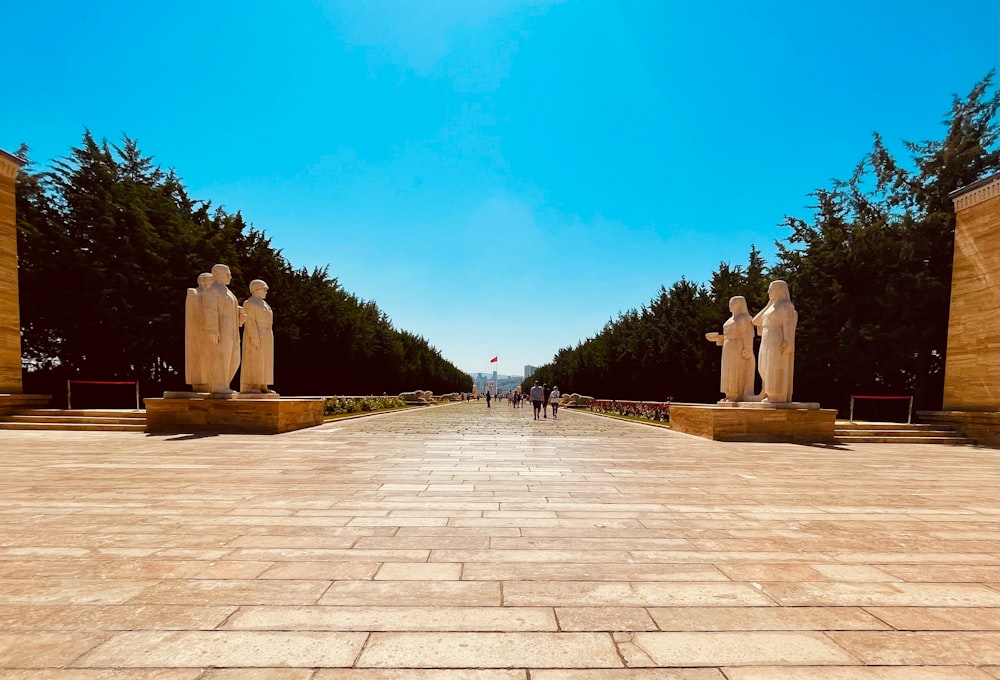 a group of statues sitting on top of a stone walkway