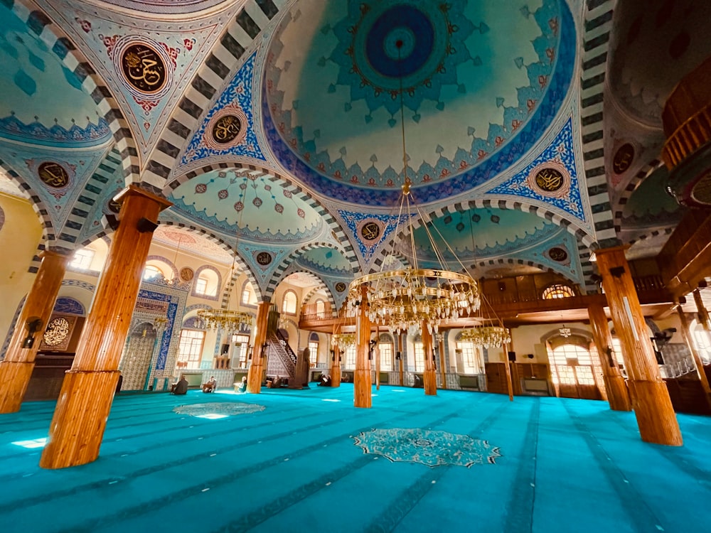 a large room with a blue carpet and a chandelier hanging from the ceiling