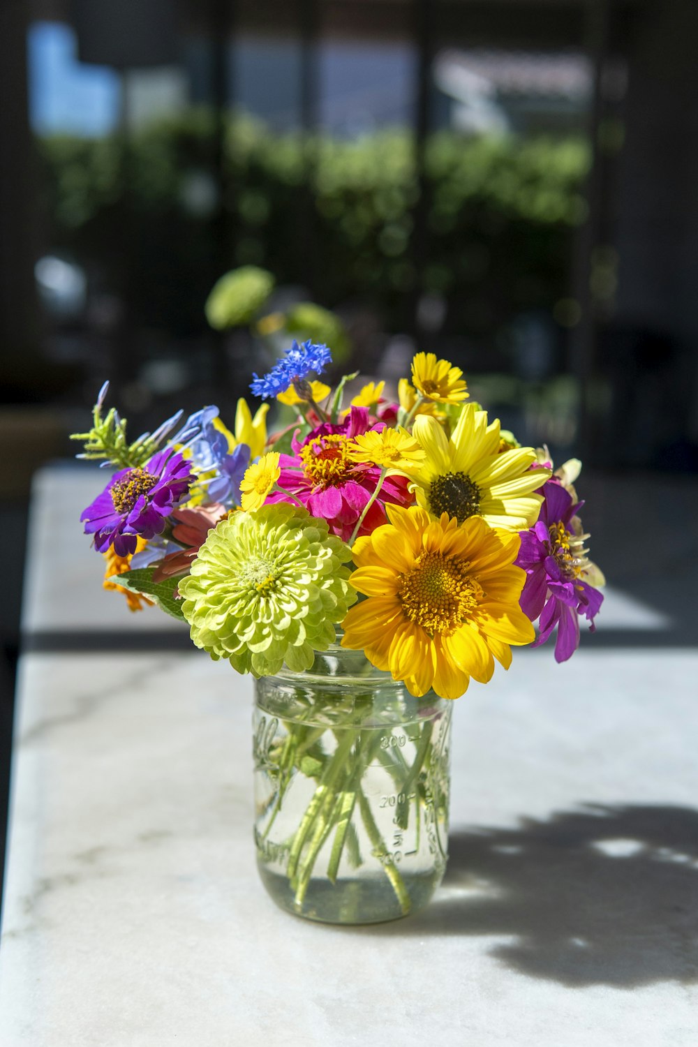 a glass vase filled with colorful flowers on top of a table