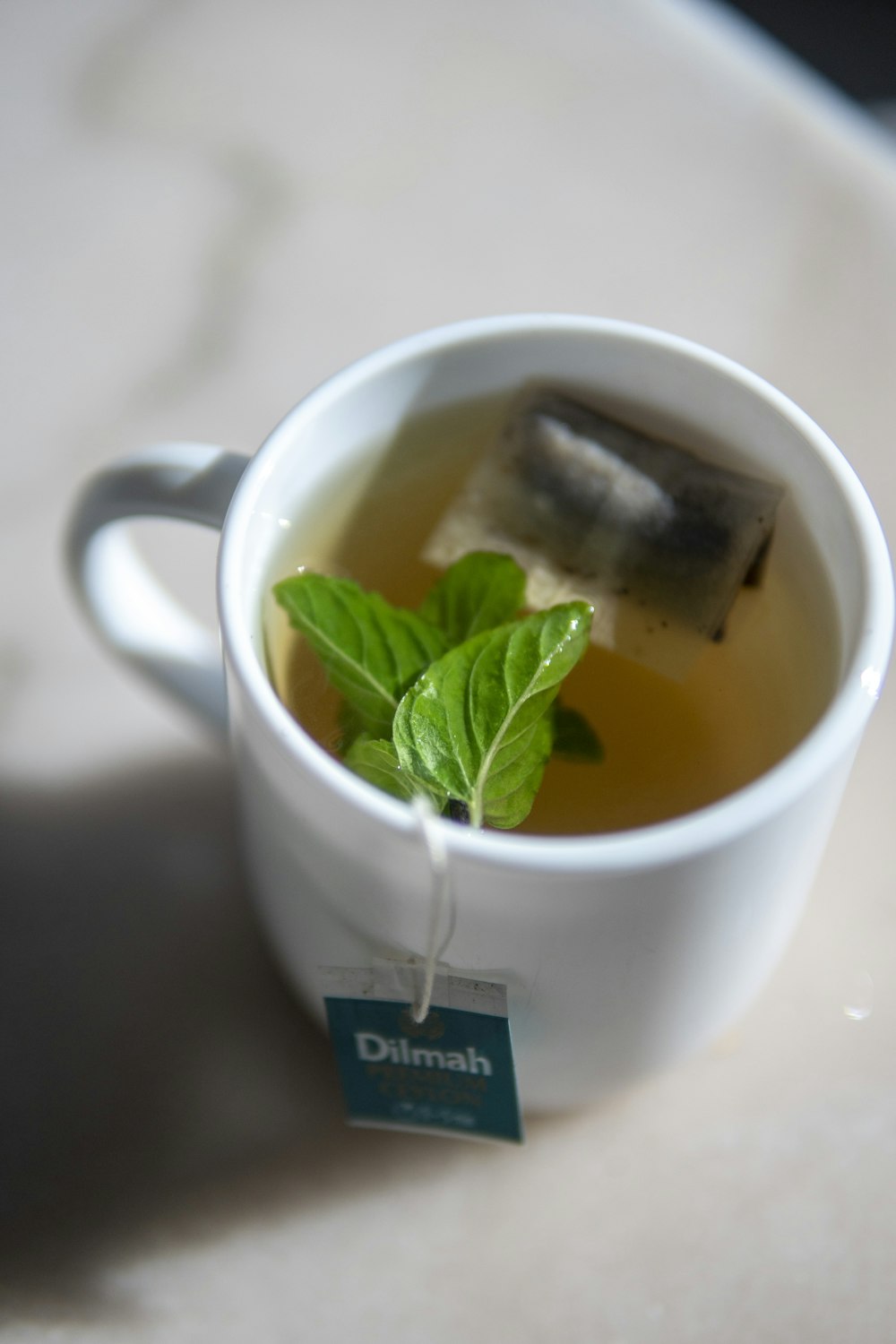a cup of tea with a green leaf in it