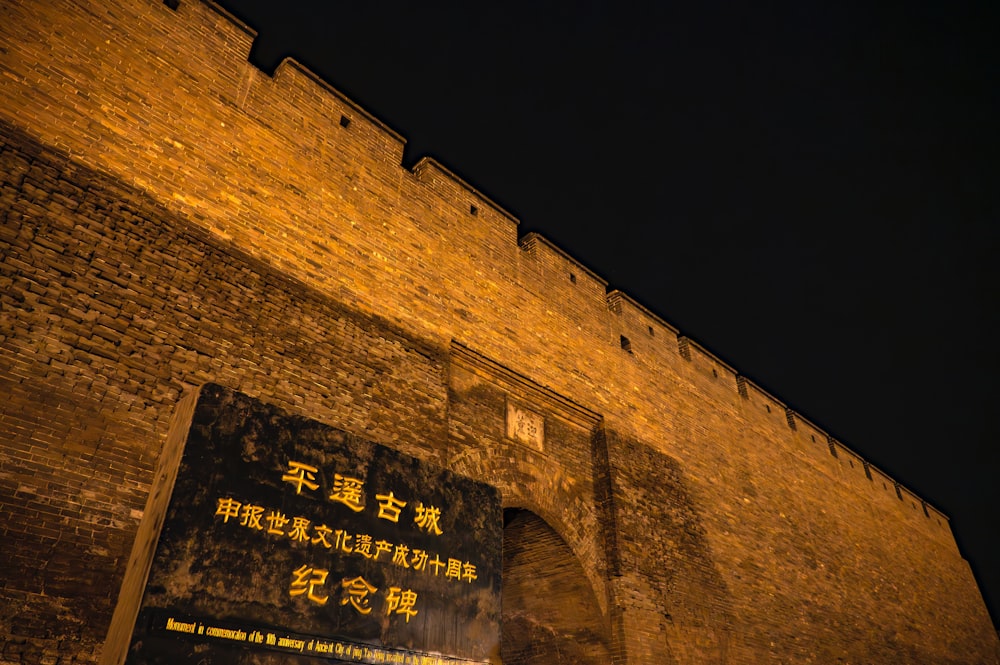 a large brick wall with a sign on it