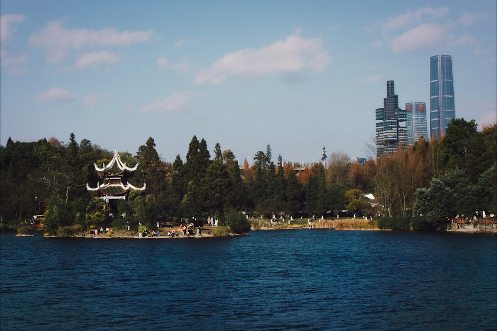 a body of water surrounded by trees and tall buildings