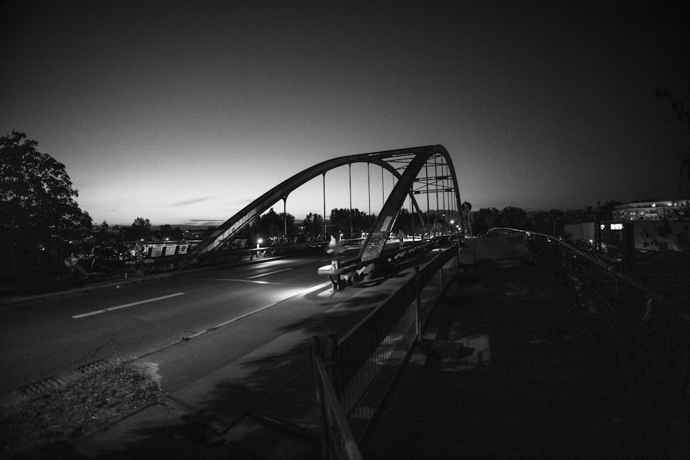 a black and white photo of a bridge at night