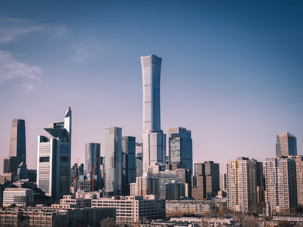 a city skyline with tall buildings and a blue sky