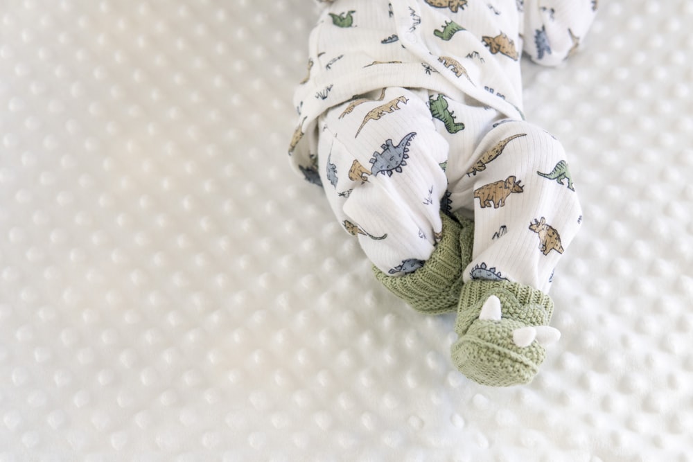 a baby laying on top of a white blanket