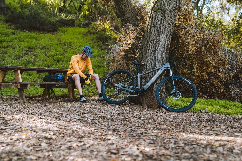 a man sitting on a bench next to a bike