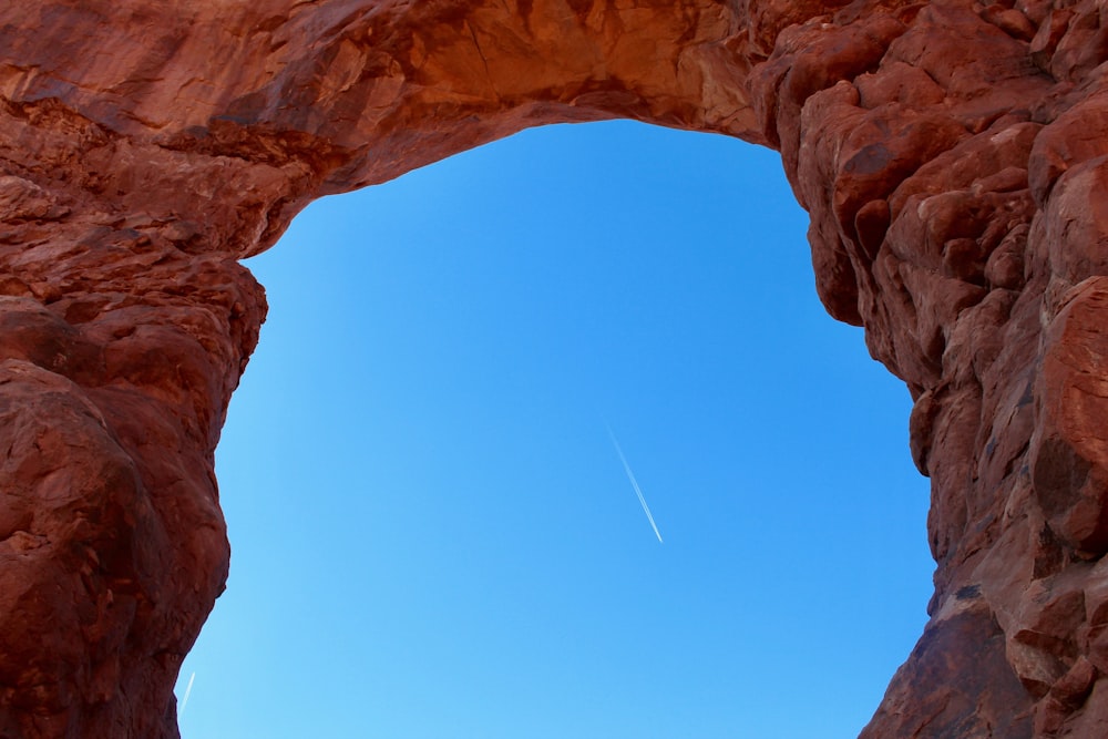 an arch in a rock formation with a clear blue sky in the background