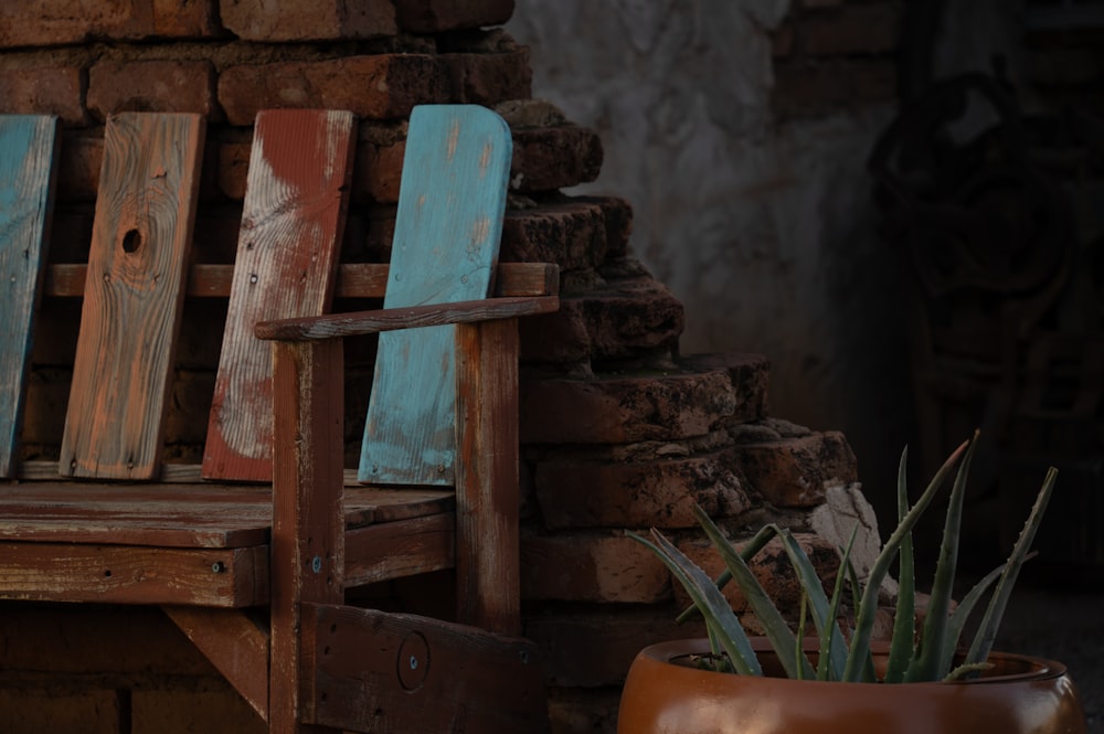 a wooden bench sitting next to a brick wall