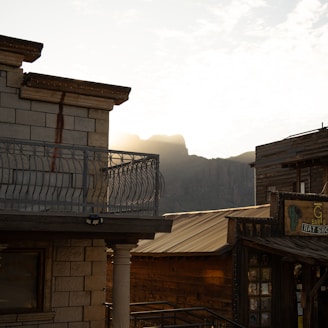 a building with a balcony and mountains in the background