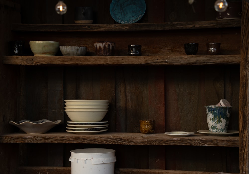 a wooden shelf filled with lots of dishes