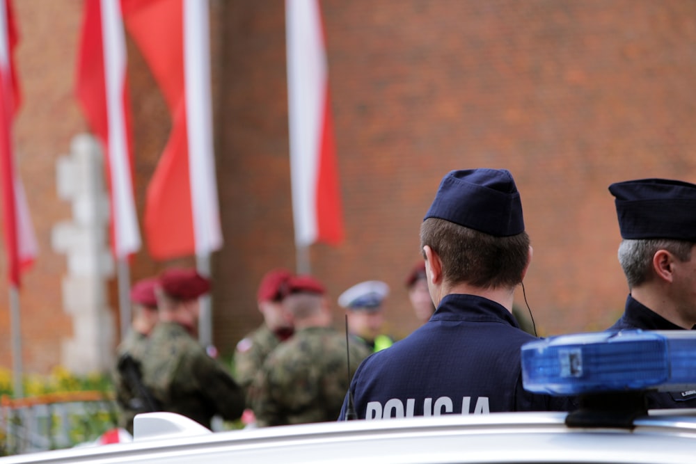 two police officers standing in front of a police car