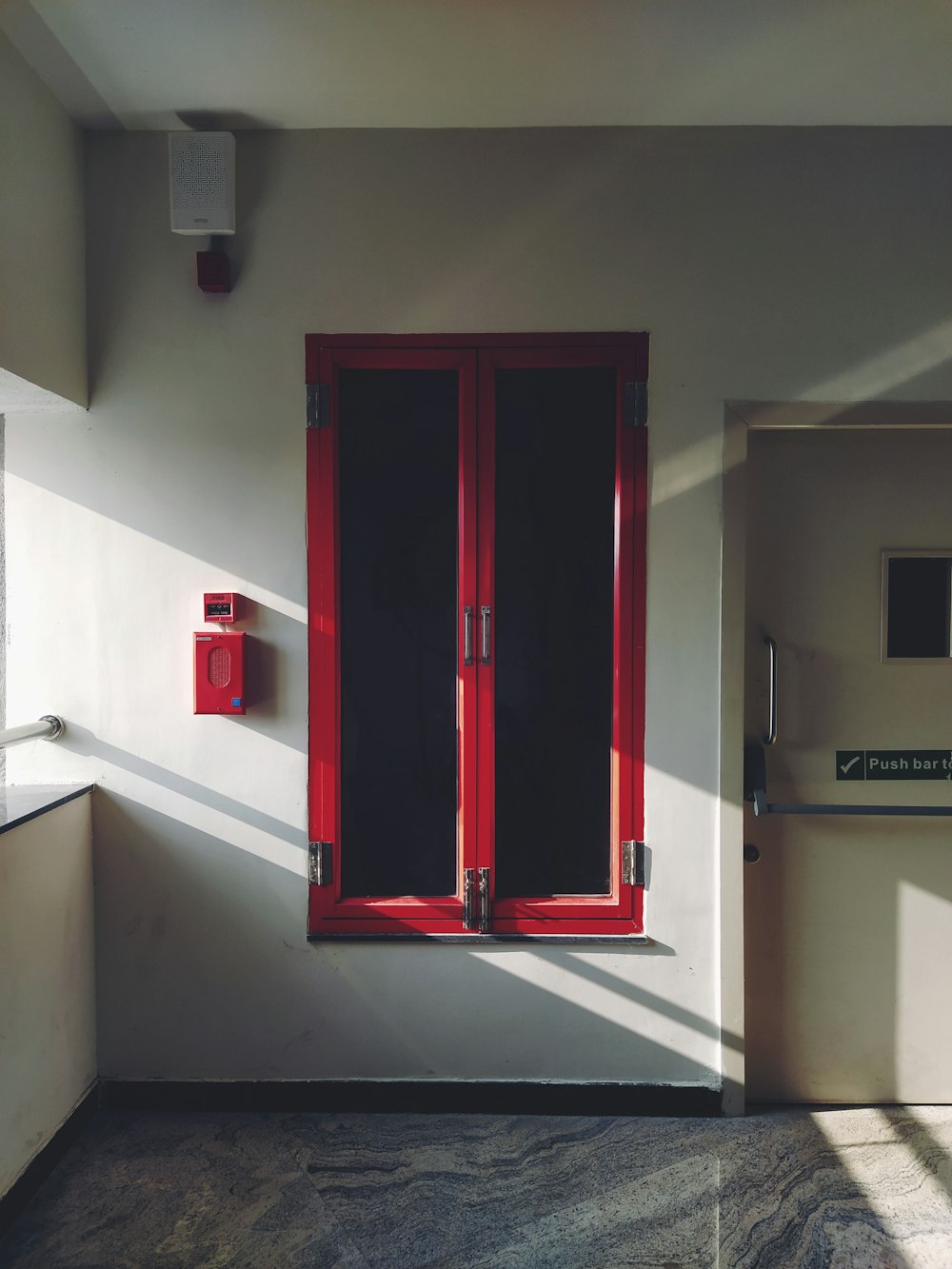 a room with a red window and a white wall